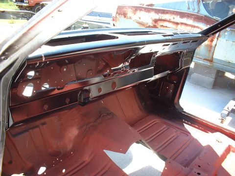 1967 Mercury Cyclone - The interior of a 1967 Mercury Cyclone shows a removed dashboard and red floor pan, with other vehicles in the background.
