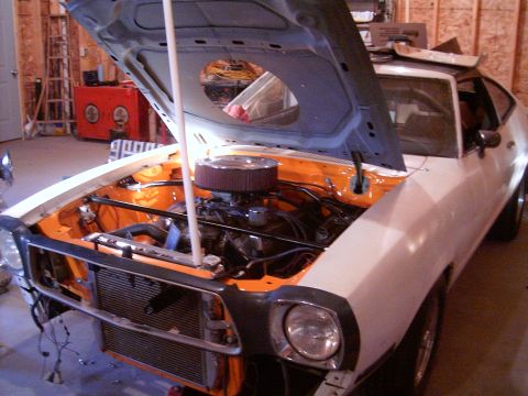1978 Ford Mustang II - Front view of a 1978 Ford Mustang II with its hood open, revealing the engine and surrounding components.