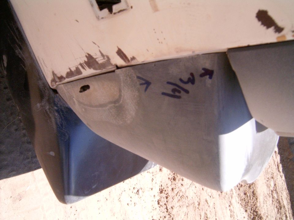 Close-up of a car's lower body panel with '3/4' written on it