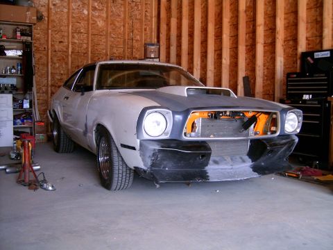 1978 Ford Mustang II - A Ford Mustang II in a garage, showing its front end with a hood scoop and incomplete grille.