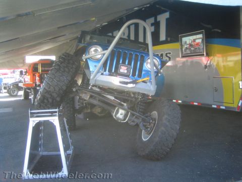 1990 Ford Bronco - blue off-road buggy with exposed coilover suspension and a tube front bumper is parked beside a Superlift trailer.