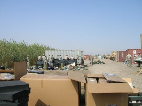 1996 Ford Bronco - Military personnel are gathered around shipping containers and boxes in an outdoor staging area.