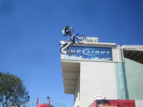 1990 Ford Bronco - motocross rider rides nearly vertical on a blue dirt bike just above a Bud Light building sign.