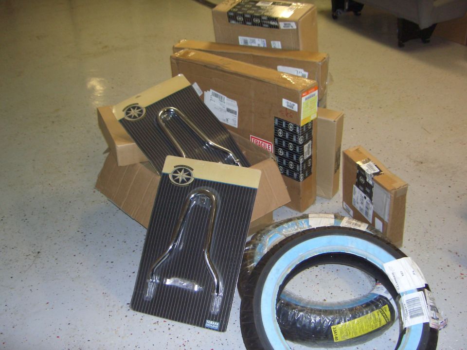 Two chrome motorcycle backrests and two tires with light blue sidewalls