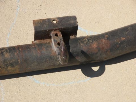 1974 Ford Bronco - A close-up view of a heavily rusted metal component, possibly a bracket or frame piece, resting on a concrete surface.