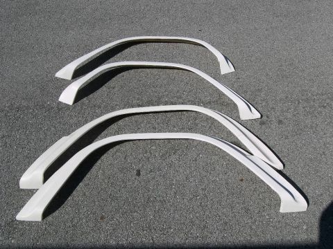 1974 Ford Bronco - Set of four white fender flares displayed on a gray asphalt surface.