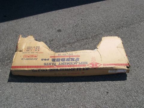 1974 Ford Bronco - A damaged cardboard box for a vehicle fender is shown on asphalt, with text indicating it is a replacement part for models from 1973-1979.