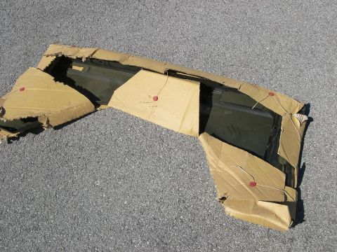 1974 Ford Bronco - A car door, likely for a classic vehicle, is shown partially unwrapped from its cardboard shipping container.