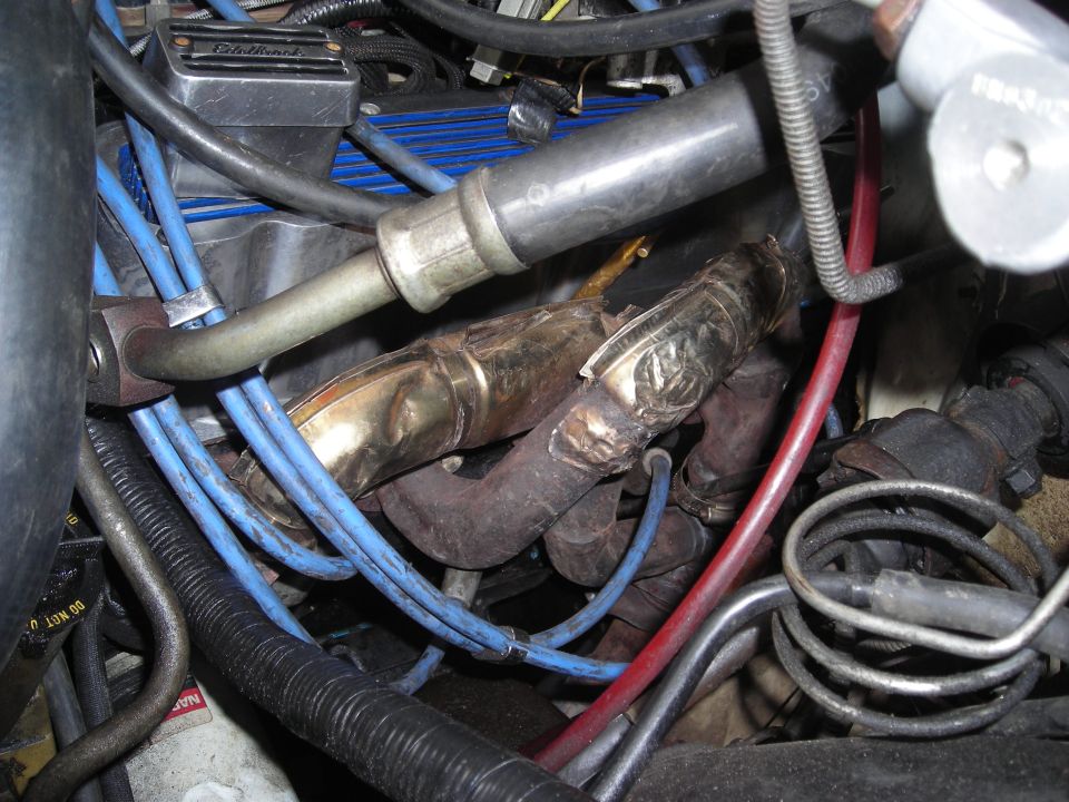 Close-up of engine components, including exhaust manifold and spark plug wires