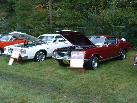 1973 Ford Ranchero - A red 1967 Ford Mustang coupe is displayed with its hood open, alongside other vehicles.