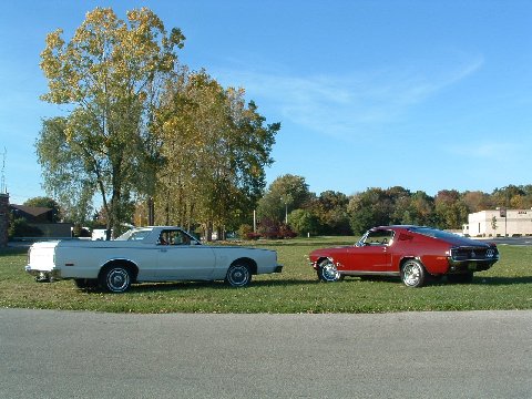 1973 Ford Ranchero - A light-colored 1972 Ford Ranchero is parked next to a red car under a clear blue sky.
