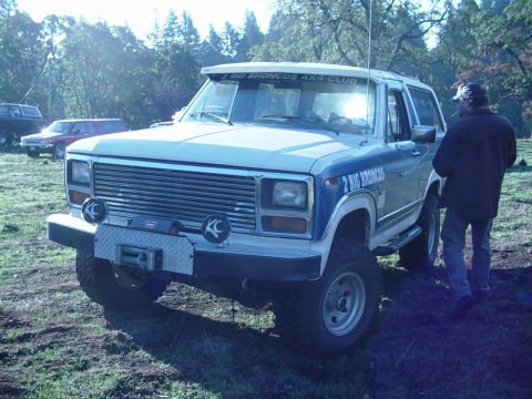 1985 Ford Bronco - A Ford Bronco with "2 BIG BRONCOS 4X4 CLUB" text is seen from the front-three-quarter angle.