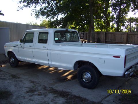 1978 Ford Bronco - White square-body Ford crew cab long-bed pickup photographed from the driver's-side rear three-quarter angle on a concrete driveway, dated…