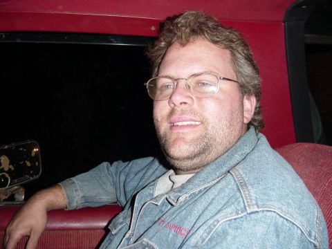 1985 Ford Bronco - Man with glasses and a denim jacket is inside a vehicle.
