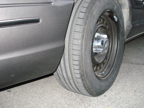 2000 Ford Crown Victoria - Close-up of the rear wheel and fender of a 2000 Ford Crown Victoria.