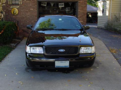 2003 Ford Crown Victoria - A black 2003 Ford Crown Victoria is parked in front of a garage.
