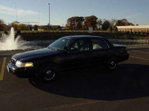 2003 Ford Crown Victoria - Black 2003 Ford Crown Victoria parked near a fountain and football field.