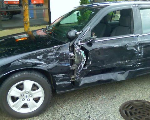 2003 Ford Crown Victoria - Driver's side of a black 2003 Ford Crown Victoria showing extensive collision damage.