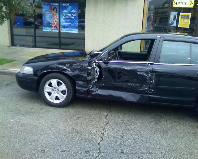 Black 2003 Ford Crown Victoria with smashed passenger side door and fender