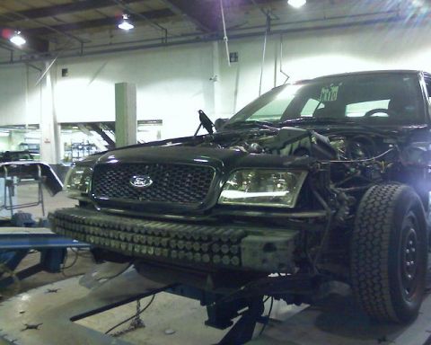 2003 Ford Crown Victoria - Front view of a 2003 Ford Crown Victoria undergoing repairs in a workshop.