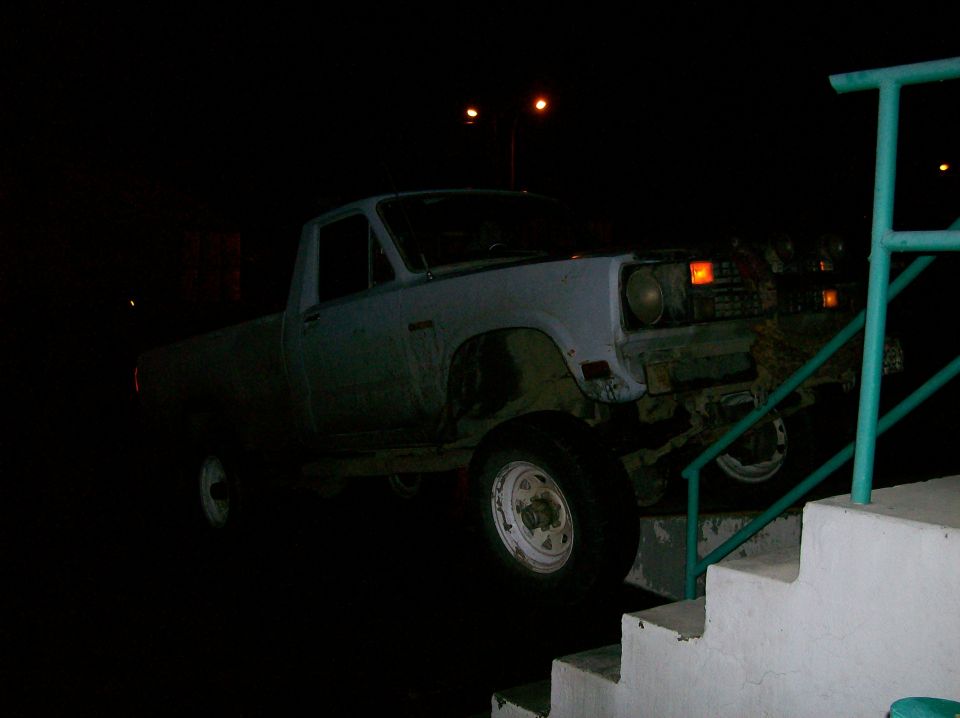 Pickup truck with front end damaged, partially on stairs