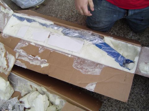 1978 Ford Bronco - A blue part is packed in a cardboard box with foam for protection.