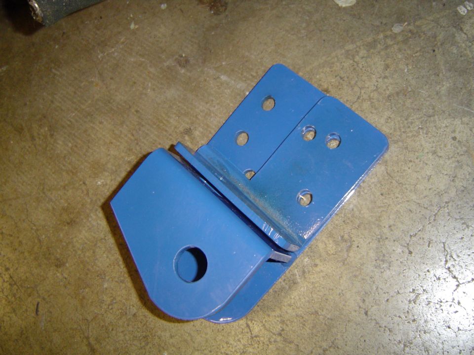 Blue painted steel fabricated bracket on a concrete floor