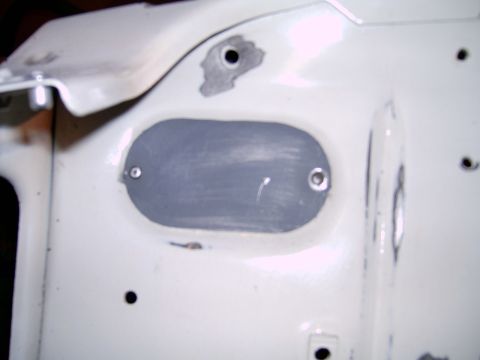 1978 Ford Mustang II - Close-up of a white car body panel showing a grey insert with screw fasteners.