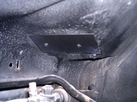 1978 Ford Mustang II - Close-up view of a bolted metal plate on a vehicle's undercarriage.