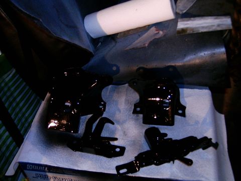 1978 Ford Mustang II - Several black painted automotive parts are drying on paper towels, possibly after being cleaned or refurbished.