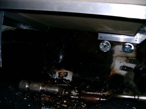 1978 Ford Mustang II - The undercarriage of a vehicle shows signs of wear and tear, with visible components and some debris.