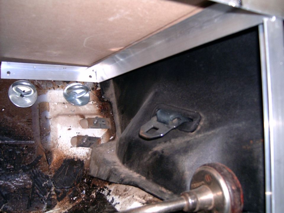 Interior view of a vehicle's cargo area with metal framing and tie-down rings