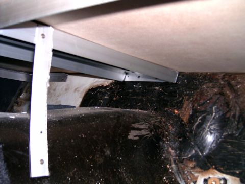 1978 Ford Mustang II - The interior of a vehicle's rear wheel well and trunk area shows signs of rust and damage, with added metal bracing.