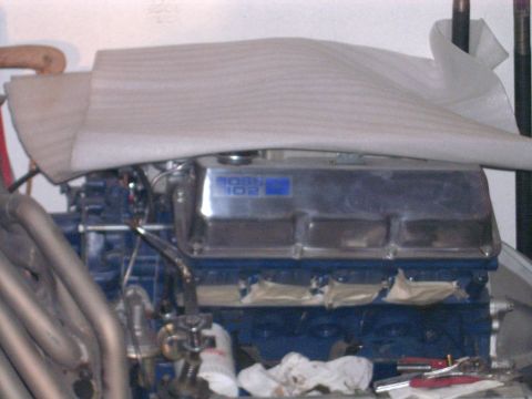 1978 Ford Mustang II - Close-up of an engine a "BOSS 302" valve cover and exhaust headers, partially covered by foam padding.