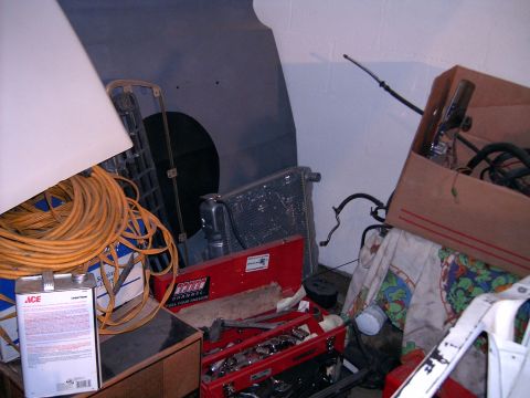 1978 Ford Mustang II - Various automotive parts and tools are stored in a cluttered garage space.