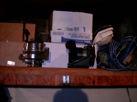 1978 Ford Mustang II - Various automotive parts, including an alternator and power steering pump, are stored on a shelf.
