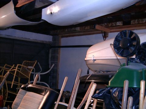 1978 Ford Mustang II - Interior car seat and roof-top carrier are visible among other stored items in a garage.