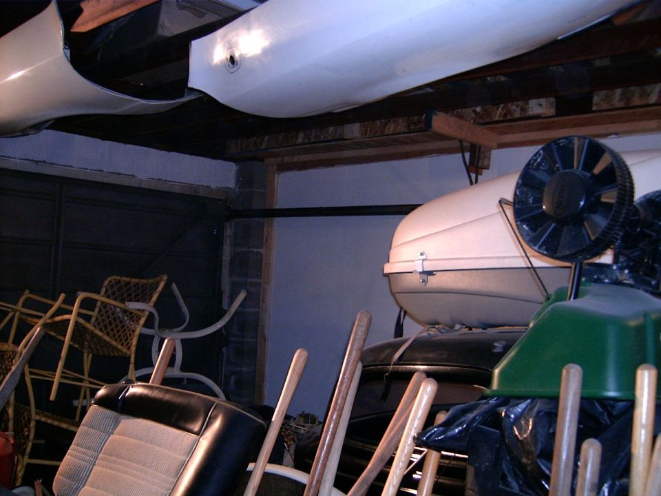 Car interior parts and a roof-top carrier stored in a cluttered garage