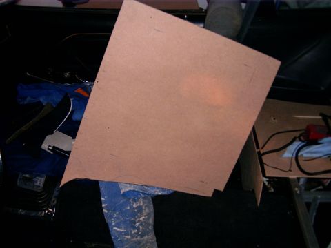 1978 Ford Mustang II - A cardboard template is placed on the floor of a vehicle's interior, next to a door panel and some tools.