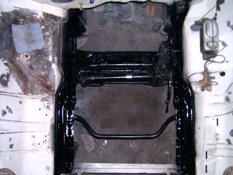 1978 Ford Mustang II - The underside of a vehicle's front end, showing the frame and suspension components after being painted.