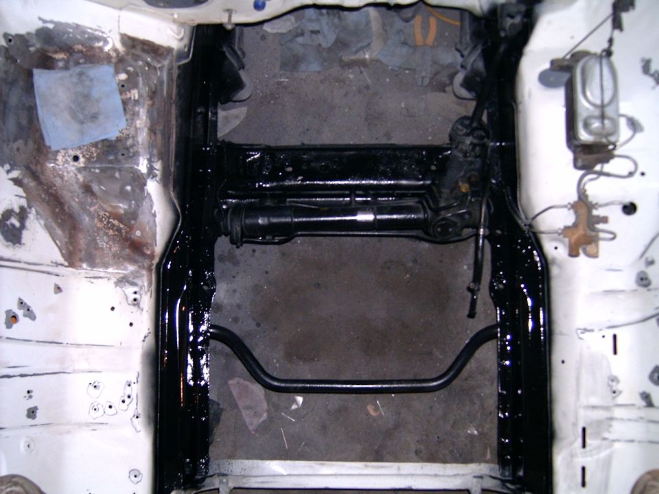 Car's front subframe and sway bar, with brake lines and master cylinder visible