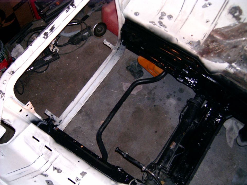 1978 Ford Mustang II chassis with black painted frame rails, suspension components, and an orange jack stand