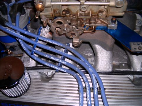 1978 Ford Mustang II - Close-up of an engine bay blue Ford Racing spark plug wires and a carburetor, with visible part numbers.