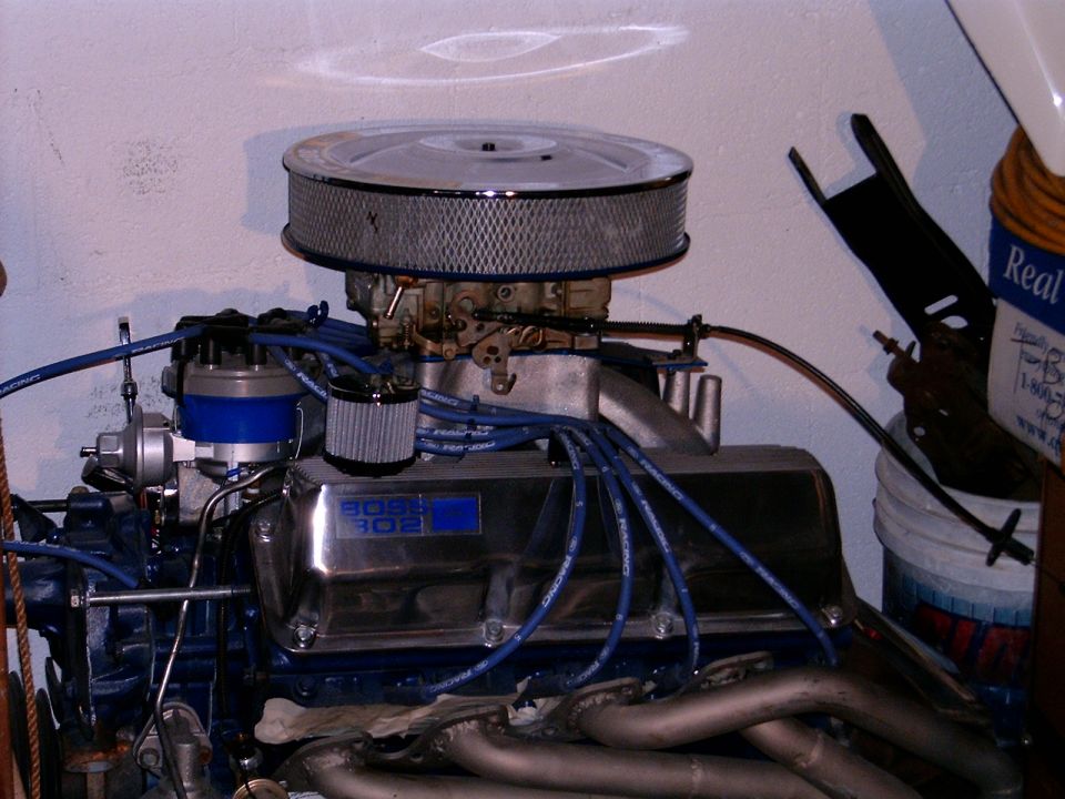 Engine with chrome air cleaner, carburetor, and "BOSS 302" valve covers. Blue spark plug wires and distributor cap visible