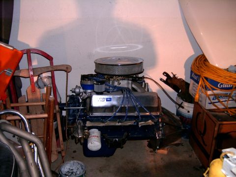 1978 Ford Mustang II - A Ford V8 engine is shown with various items in the background, including a sled and storage bins.