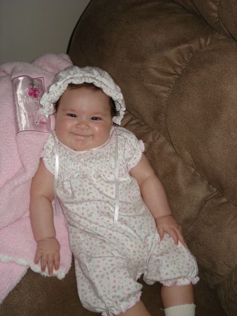 2000 Ford Crown Victoria - Baby in bonnet and romper on couch with pink blanket.