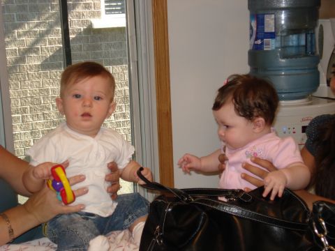 2000 Ford Crown Victoria - Two babies are held by adults near a water cooler and a window.