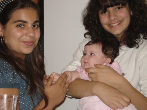 2000 Ford Crown Victoria - Two young women interact with a baby in a close-up indoor shot.