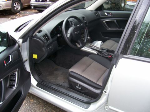 2001 Ford Crown Victoria - The interior of a silver sedan is shown, with a view of the dashboard and seats. Another vehicle is parked nearby.