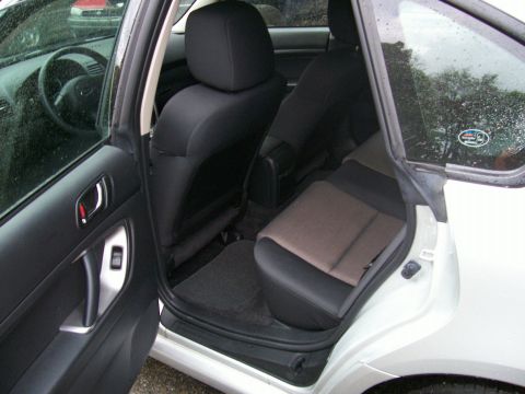 2001 Ford Crown Victoria - Interior view of a white car, focusing on the rear passenger area and driver's side door.